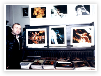 A man standing in front of several pictures.