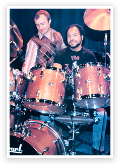 Two men are playing drums together in a band.
