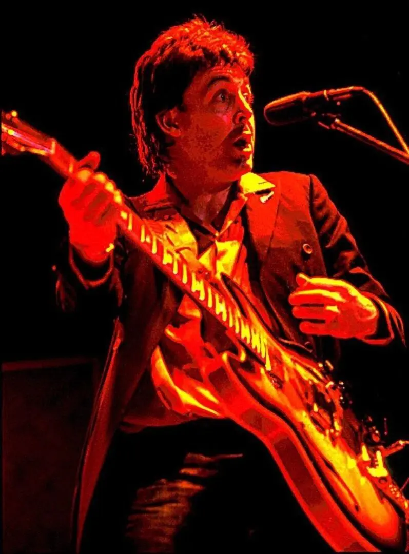 A man playing guitar in front of a microphone.